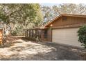 Spacious two-car garage with a brick and siding exterior, alongside a screened-in porch at 1101 N Valencia Ave, Howey In The Hills, FL 34737