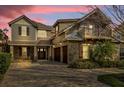 Beautiful home featuring a stone facade, 3-car garage, and a welcoming paver driveway at twilight at 11507 Center Lake Dr, Windermere, FL 34786