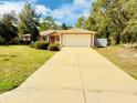 Inviting single-story home featuring an attached two-car garage and a long, private driveway at 14410 Sw 79Th Ter, Ocala, FL 34473