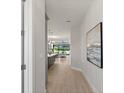 Hallway view with a glimpse of a modern kitchen and dining area with sliding glass doors at 1811 Simonton Ave, Orlando, FL 32806