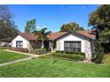 Charming home showcasing stone accents, a well-maintained lawn, and lovely landscaping at 207 Pembrook Pl, Longwood, FL 32779