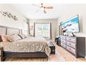 Bright main bedroom featuring a large window, modern furnishings, and a ceiling fan at 2212 Antilles Club Dr, Kissimmee, FL 34747