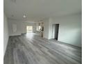 Bright and spacious living room featuring gray wood flooring, a kitchen view, and neutral paint at 2703 Sw 162Nd Street Rd, Ocala, FL 34473