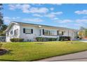 Well-maintained single-story home with a white exterior, dark shutters and a lush green lawn at 29 Jasmine Dr, Debary, FL 32713