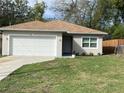 Single Gathering home featuring a manicured lawn, attached garage, and a wooden fence in a well-lit neighborhood at 424 Crabtree Ave, Orlando, FL 32835