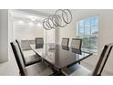 Elegant dining room featuring a modern light fixture, statement wall, and a sleek dining table at 841 Benjamin Trl, Davenport, FL 33837