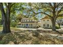 Traditional home featuring a wraparound porch and a detached garage with mature trees at 9332 Windy Ridge Rd, Windermere, FL 34786