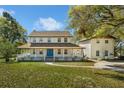 Charming two-story home with a spacious porch and a bright blue front door at 9332 Windy Ridge Rd, Windermere, FL 34786