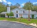 Charming two-story home featuring a blue exterior, manicured lawn, mature trees, and a welcoming front entrance at 978 Cobbler Ct, Longwood, FL 32750