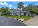 Charming two-story home featuring a blue exterior, manicured lawn, mature trees, and a welcoming front entrance at 978 Cobbler Ct, Longwood, FL 32750