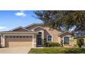 Charming single-story home featuring a two-car garage, well-maintained landscaping, and a welcoming facade at 1018 Highland Meadows St, Davenport, FL 33837