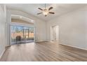 Bright living room with vaulted ceilings, ceiling fan, sliding doors, and durable laminate flooring at 1018 Highland Meadows St, Davenport, FL 33837