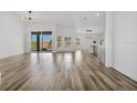 Bright, open-concept living room features wood floors, large windows, and seamless flow to the outdoor space at 11706 Regal Ridge Ln, Clermont, FL 34711