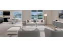 Bright living room featuring stylish furniture, large windows, and an adjacent dining area with views of the pond at 1210 Alstonia Ln, Mount Dora, FL 32757