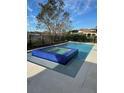 Sparkling pool and hot tub featuring vibrant blue tiling, set against a backdrop of mature trees at 14544 Avenue Of The Rushes, Winter Garden, FL 34787