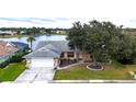 Charming single-story home with mature trees, a two-car garage, and serene lake view at 14712 Eagles Crossing Dr, Orlando, FL 32837