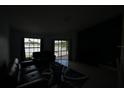 Dim living room with modern furniture and a tranquil lake view through sliding glass doors at 14712 Eagles Crossing Dr, Orlando, FL 32837