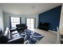 Bright living room featuring modern blue accent wall, comfortable sofas, and a stylish rug at 14712 Eagles Crossing Dr, Orlando, FL 32837