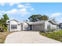 Attractive single-story home with attached two-car garage, long driveway, and manicured landscaping at 1499 Courtland Blvd, Deltona, FL 32738