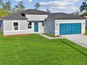 Charming single-Gathering home with a well-manicured lawn and a stylish blue garage door at 15354 Sw 43Rd Avenue Rd, Ocala, FL 34473