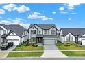 Well maintained two-story home with gray siding, stone accents, landscaped front yard and modern design at 17052 Cercis Loop, Clermont, FL 34711