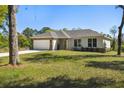 Charming single-story home with a two-car garage, stone accents, and a well-maintained lawn at 1870 Blackwelder Rd, De Leon Springs, FL 32130