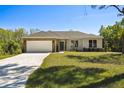 Charming single-story home featuring a two-car garage, stone accents, and a well-manicured lawn at 1870 Blackwelder Rd, De Leon Springs, FL 32130