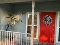 Close-up of the vibrant red front door with decorative wreath, complemented by a well-kept front porch at 217 Wilmer Ave, Orlando, FL 32811