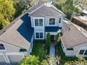 An elevated aerial view of the luxury home featuring a beautifully landscaped yard, mature trees, and a brick driveway at 254 Sylvan Blvd, Winter Park, FL 32789