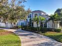 Beautiful facade with palm trees, well-manicured landscaping, and paver driveway leading to the garage and front entrance at 254 Sylvan Blvd, Winter Park, FL 32789