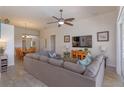 Spacious living room featuring tile floors, a ceiling fan, and a comfortable sofa at 2683 Manesty Ln, Kissimmee, FL 34747