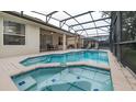 Relaxing screened-in pool area with a spa, lounge chairs, and covered patio, perfect for outdoor entertainment at 2683 Manesty Ln, Kissimmee, FL 34747