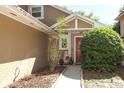 Inviting front entrance with a red door, complemented by attractive landscaping at 3623 S Saint Lucie Dr, Casselberry, FL 32707