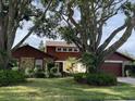 Charming front yard view of house showcasing mature trees and lush landscaping at 5220 Jade Cir, Orlando, FL 32812