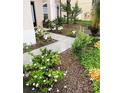 Well-manicured front yard with lush garden beds, flowers, and a concrete walkway leading to the entrance at 548 Big Sioux Ct, Kissimmee, FL 34759