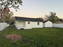 Exterior back view of the house with a large backyard and white vinyl fencing at 636 Coke Ave, Winter Garden, FL 34787