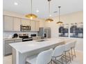 Contemporary kitchen features a large island, pendant lights, and stainless steel appliances at 6400 Tabebuia Pkwy, Winter Garden, FL 34787