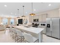 Modern kitchen features a large island with bar seating, stainless steel appliances and pendant lights at 6400 Tabebuia Pkwy, Winter Garden, FL 34787