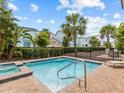 Community pool and patio area surrounded by mature landscaping and colorful buildings at 8086 Knee Deep Rd, Kissimmee, FL 34747