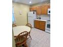 Eat-in kitchen with tile floor features a white refrigerator, stove, and lots of cabinets at 9 Escondido Cir # 88, Altamonte Springs, FL 32701