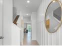 Inviting entryway featuring light tile floors, white walls with elegant wainscoting, and an oval mirror accent at 994 Lido Dr, Howey In The Hills, FL 34737