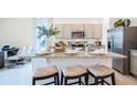 Modern kitchen features gray cabinets, granite counters, stainless appliances, and a functional island with seating at 994 Lido Dr, Howey In The Hills, FL 34737
