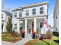 Charming two-story home featuring a well-manicured lawn and a welcoming front porch with a vibrant red door at 1073 Sadler Oaks Way, Winter Garden, FL 34787