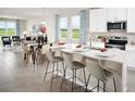 Bright, open-concept kitchen featuring white cabinetry, stainless steel appliances, and a breakfast bar at 1146 Foreshore Ln, Haines City, FL 33844