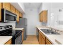 Kitchen featuring wood cabinets, stainless steel appliances, and a double sink at 13037 Mulberry Park Dr # 529, Orlando, FL 32821
