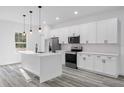 Bright kitchen features stainless steel appliances, a center island, and sleek white cabinets at 13141 Sw 83Rd Ter, Ocala, FL 34473