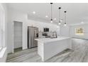 This modern kitchen is complete with white cabinets, stainless steel appliances, and a large island at 13141 Sw 83Rd Ter, Ocala, FL 34473