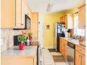 Bright kitchen featuring light wood cabinets, tile backsplash, and stainless steel appliances at 1512 N Hastings St, Orlando, FL 32808