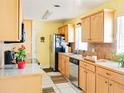 Well-lit kitchen featuring wood cabinets, modern appliances, granite countertops, and tile flooring at 1512 N Hastings St, Orlando, FL 32808