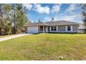 Charming single-story home featuring a two-car garage and well-manicured front lawn at 16121 Sw 24Th Court Rd, Ocala, FL 34473